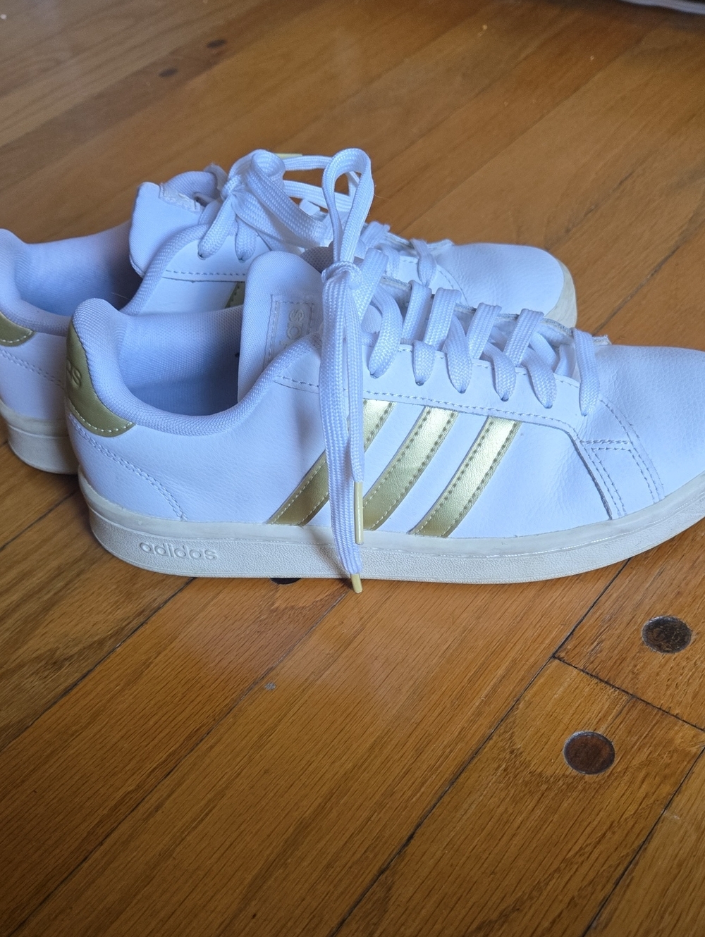 Adidas Women's White Sneakers with Gold Three-Stripes